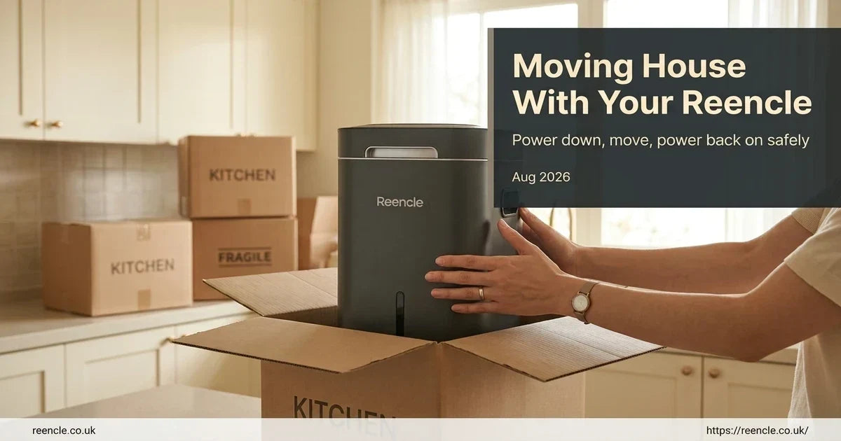 Hands placing a dark grey Reencle composter into an open cardboard moving box on a kitchen counter.